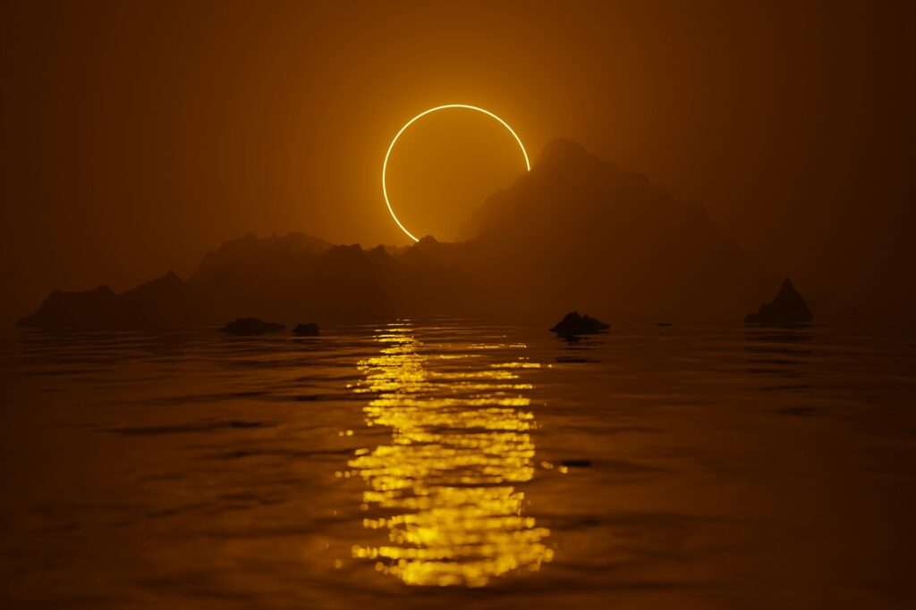Solar eclipse over a hazy mountain silhouette, with a glowing ring of light reflecting across calm water in warm golden tones.