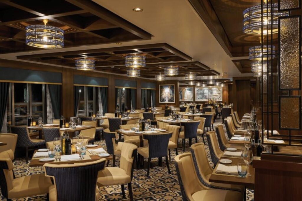 The inviting interior of La Cucina Italian restaurant on Norwegian Bliss, showcasing elegant dining tables, plush seating, and warm lighting, for a cozy and upscale dining experience.
