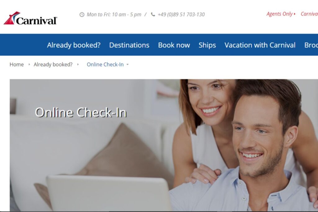 A cheerful couple is seen performing an online check-in on a laptop, symbolizing convenient digital services provided by Carnival Cruise Lines.