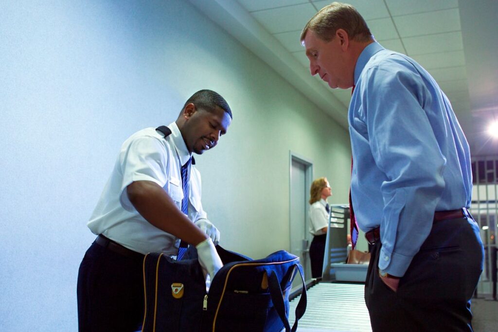 A security personnel checking the bag of a passenger before boarding the cruise ship.